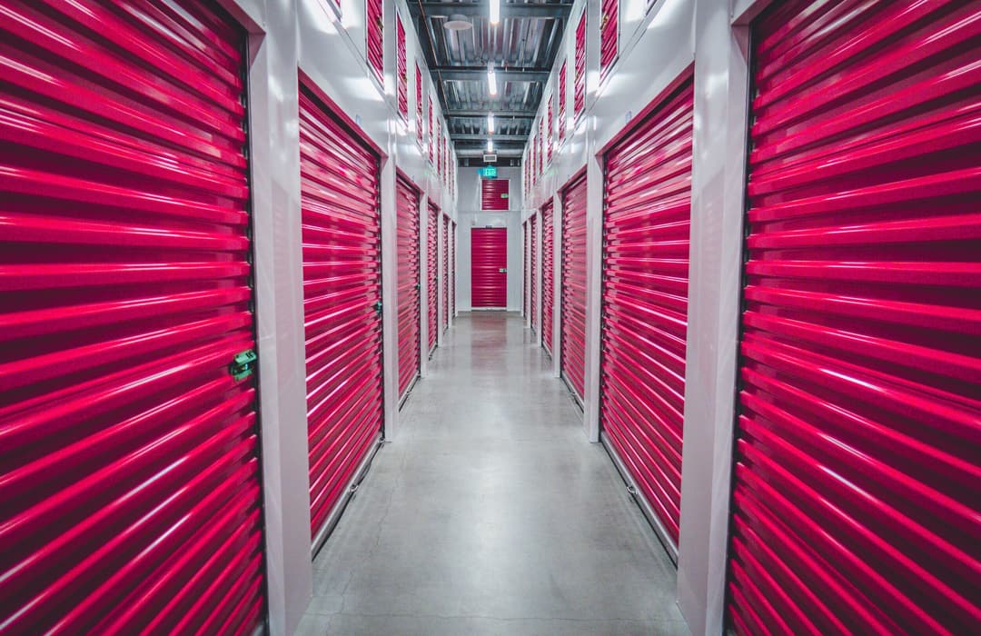 Long interior corridor lined with red roll-up doors on both sides