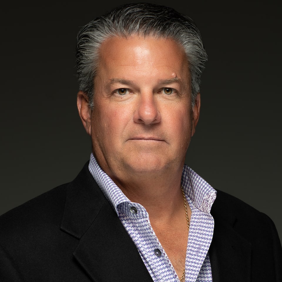 Studio portrait of Bradley Rosely, Partner of Carbon River Capital, in a dark jacket and check shirt