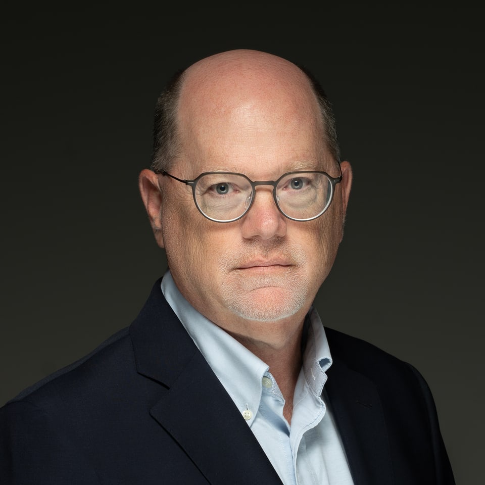 Studio portrait of David Levitt, Managing Partner of Carbon River Capital, in a navy jacket and glasses