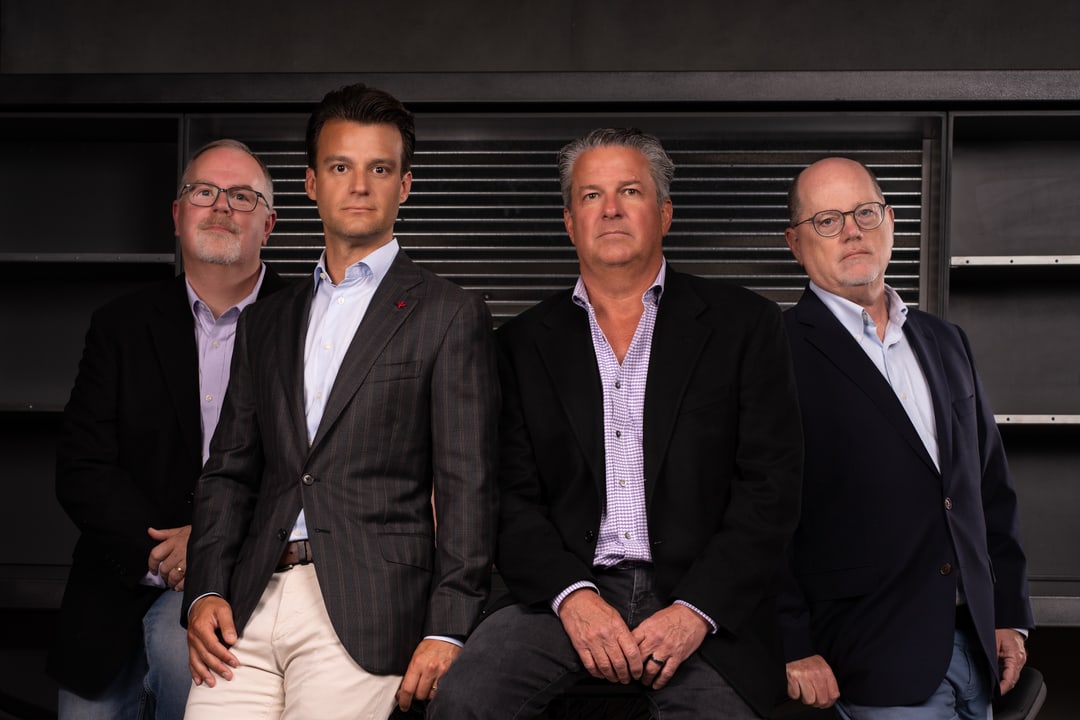 Ryan Van Dam, Max Benedict, Bradley Rosely and David Levitt of Carbon River Capital, standing together in front of a dark steel wall