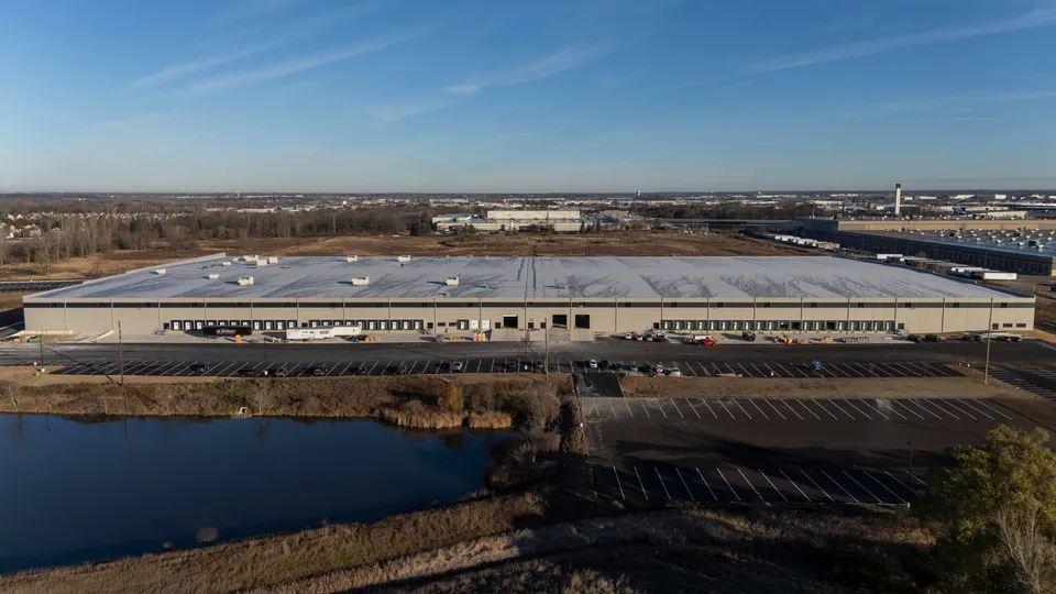 Wide aerial view of the 60th Street Warehouse with a retention pond in the foreground