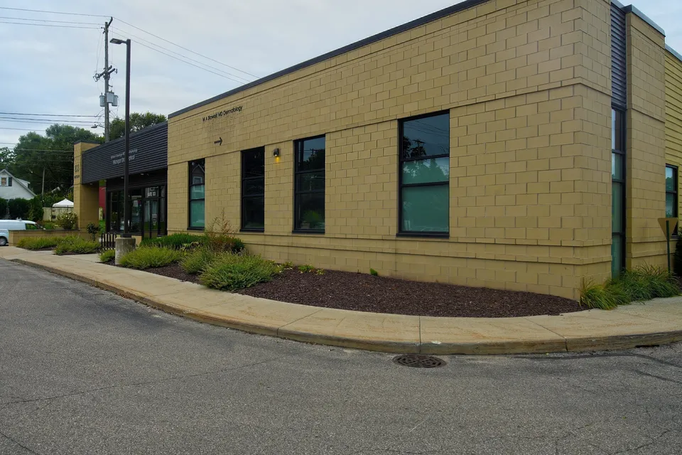 Side elevation of 833 Michigan Street NE showing tan block walls and landscaping